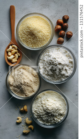 Various type of flour creates visually appealing flat lay in glass bowls, nuts beside them giving off an organic vibe 131576452
