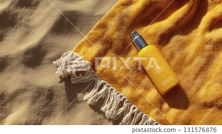 Sun protection spray bottle on sandy beach with yellow towel, emphasizing skincare and sun safety during outdoor activities 131576876