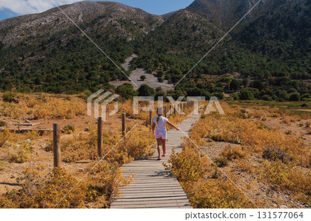 Little girl walking on wooden path in the mountains of Crete. 131577064