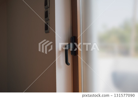 Brown metal plastic balcony door in interior with white walls. 131577090