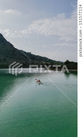 Father and daughter kayaking on picturesque Lake Kournas in Crete. Father and daughter kayaking on picturesque Lake Kournas in Crete. 131577114