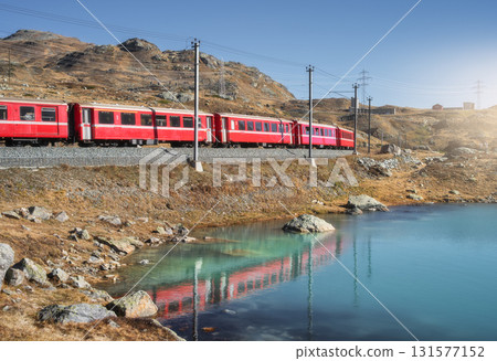 Bernina Express train near lake in Switzerland at sunset 131577152
