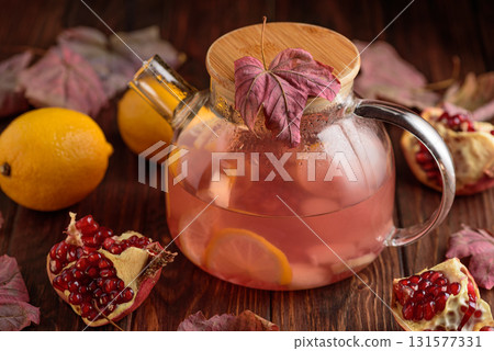 Autumn Beverage: Pomegranate Tea with Lemon and Ginger on Rustic Table 131577331