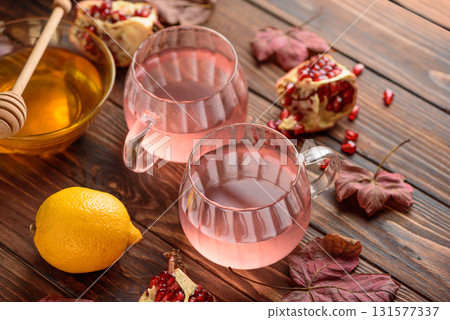 Autumn Beverage: two Cups ofPomegranate Tea with Lemon and Ginger on Rustic Table 131577337