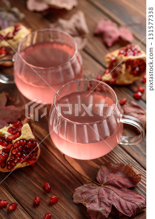 Autumn Beverage: two Cups ofPomegranate Tea with Lemon and Ginger on Rustic Table 131577338