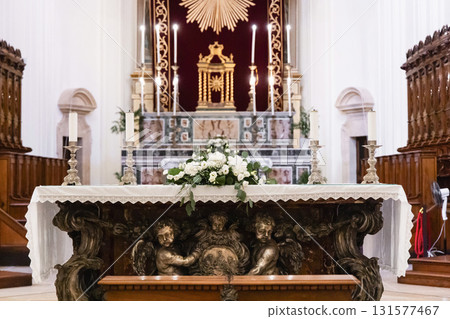 Catholic altar decorated with white ceremonial flowers Catholic altar decorated with white ceremonial flowers 131577467