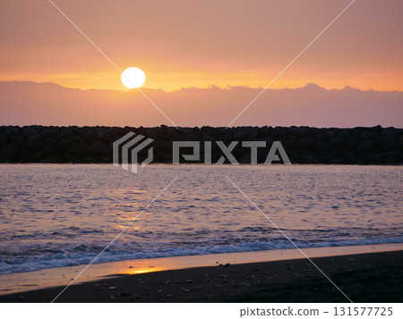 A serene beach scene at sunset with gentle waves lapping at the shore. Tenerife beach with volcanic black sand A serene beach scene at sunset with gentle waves lapping at the shore. Tenerife beach with volcanic black sand 131577725