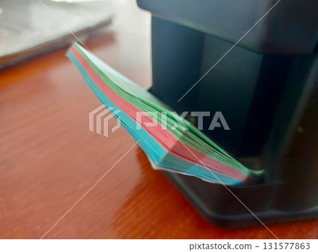 Colored Sheets for Note-Taking Arranged Neatly on a Stationery Holder at a Workspace Colored Sheets for Note-Taking Arranged Neatly on a Stationery Holder at a Workspace 131577863