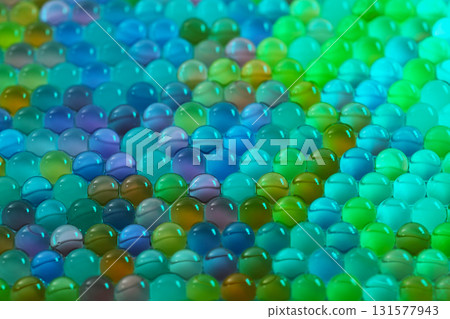 A close up of many different colored glass beads 131577943
