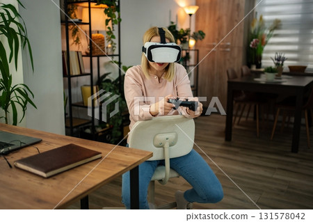 Engaging in virtual reality gaming at home with immersive technology during a cozy afternoon Engaging in virtual reality gaming at home with immersive technology during a cozy afternoon 131578042