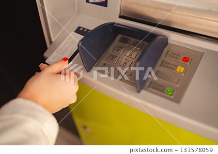 Hand inserting card into ATM for cash withdrawal in urban setting Hand inserting card into ATM for cash withdrawal in urban setting 131578059
