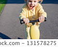Child with scooter. Yellow riding toddler fun. Summer activity outdoor road. 131578275