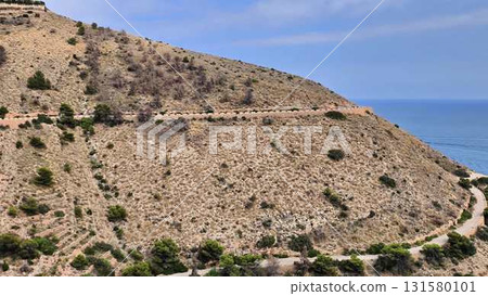 Aerial journey along a winding coastal road reveals serene beauty 131580101