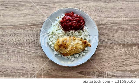 A visually appealing plate of rice, chicken a flavorful sauces 131580106