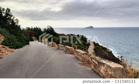 A scenic road that leads directly to the vast ocean on a cloudy day A scenic road that leads directly to the vast ocean on a cloudy day 131580111