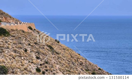 A scenic coastal road offers stunning hillside views and a castle 131580114