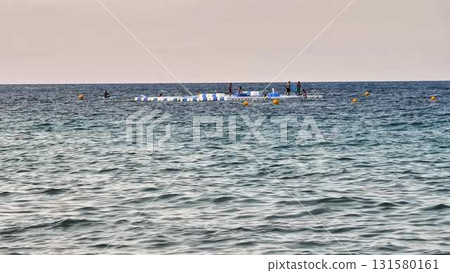 Friends gather on a raft in the ocean, enjoying laughter 131580161