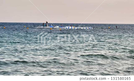 Friends gather on a raft in the ocean, enjoying laughter and views Friends gather on a raft in the ocean, enjoying laughter and views 131580165