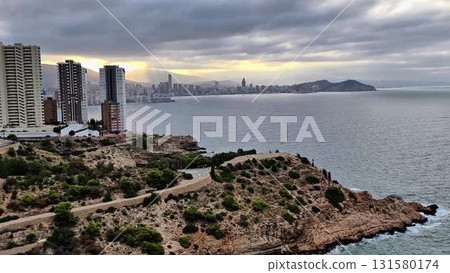 A stunning cliff view overlooks the ocean and a picturesque city 131580174