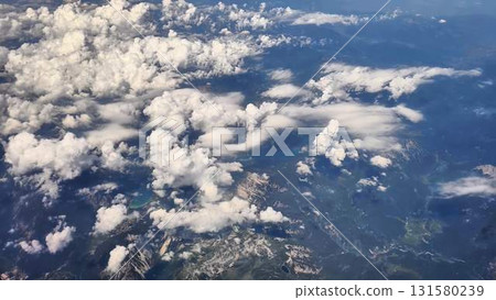 An aerial view captures a stunning cloud formation draping over majestic mountains 131580239