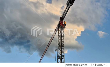 A Construction Crane Stands Against a Beautifully Dramatic Sky at Sunset or Dusk 131580259
