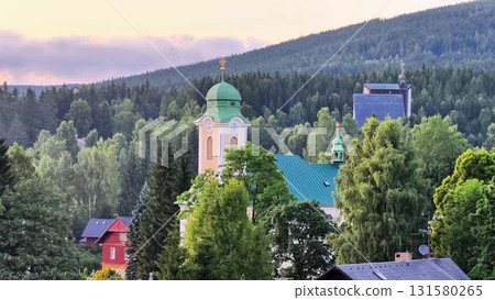 A scenic view of a beautiful church amidst lush greenery in a majestic mountain landscape A scenic view of a beautiful church amidst lush greenery in a majestic mountain landscape 131580265