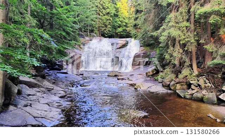 The Serene Waterfall Cascading Gracefully Through the Lush Green Forest is Breathtaking 131580266