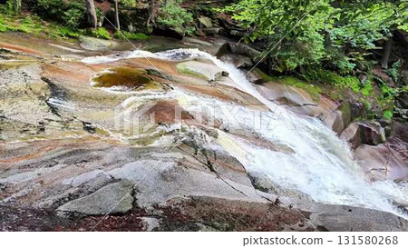 A Stunning Scenic Waterfall Cascading Gracefully Over Vibrant Colorful Rock Formation A Stunning Scenic Waterfall Cascading Gracefully Over Vibrant Colorful Rock Formation 131580268