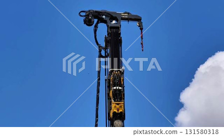A HighResolution Photograph of a Crane Arm set Against a Bright Blue Sky Background 131580318