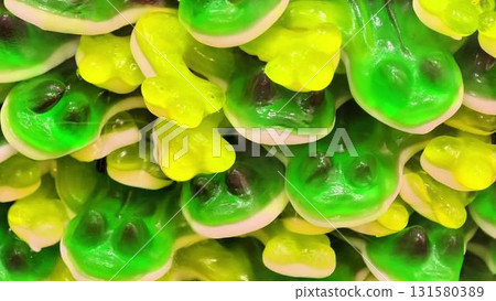 A vibrant and colorful assortment of gummy frog candies piled together in a playful way A vibrant and colorful assortment of gummy frog candies piled together in a playful way 131580389
