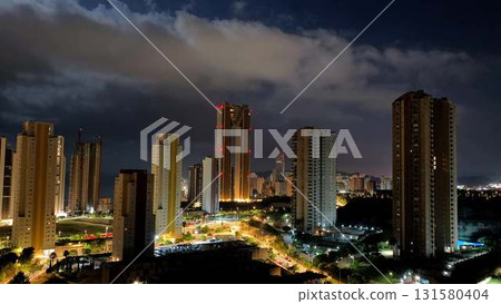 A Stunning Cityscape at Night Featuring Beautifully Illuminated Buildings and Clouds A Stunning Cityscape at Night Featuring Beautifully Illuminated Buildings and Clouds 131580404
