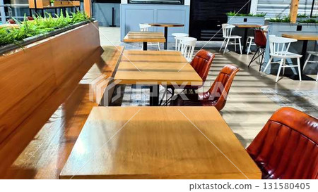 Stylish Cafe Interior with Wooden Tables and Chic Chairs for relaxation and socializing Stylish Cafe Interior with Wooden Tables and Chic Chairs for relaxation and socializing 131580405