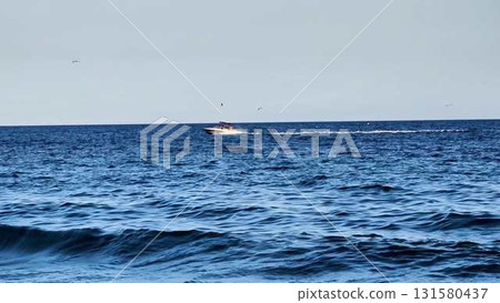 A Speeding Boat Gliding Across a Beautiful and Calm Ocean Surface on a Sunny Day A Speeding Boat Gliding Across a Beautiful and Calm Ocean Surface on a Sunny Day 131580437
