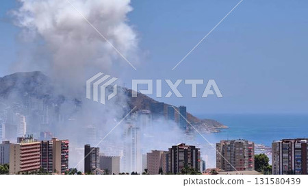 A stunning scenic coastal view showcasing smoke wafting between beautiful buildings nearby 131580439