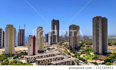 A modern city skyline features impressive towers and picturesque coastal views that attract many 131580453