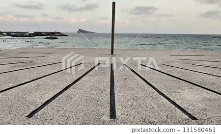 Seaside Sundial at Twilight A Captivating Coastal Perspective Under the Evening Sky 131580461