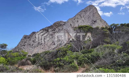 A Stunning Coastal Rock Formation Beautifully Set Against a Clear Blue Sky Above A Stunning Coastal Rock Formation Beautifully Set Against a Clear Blue Sky Above 131580486