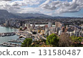 An Aerial View of a Coastal City featuring a Beautiful Marina and Stunning Scenic Mountains 131580487