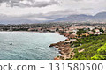A Stunning Coastal View Featuring Lush Greenery, Surrounded by Dramatic Clouds Above 131580500