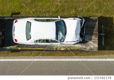 Car crash with tow truck hauling damaged car and first responders helping at accident site on American street. Vehicle collision on road in USA Car crash with tow truck hauling damaged car and first responders helping at accident site on American street. Vehicle collision on road in USA 131582178