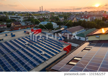 Blue photovoltaic solar panels mounted on building roof for producing clean ecological electricity at sunset. Production of renewable energy concept 131582257