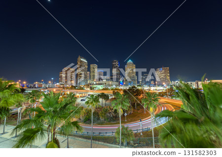 American city skyline with brightly illuminated high commercial buildings and high speed highway road. Night urban landscape of downtown district of Tampa in Florida, USA. American city skyline with brightly illuminated high commercial buildings and high speed highway road. Night urban landscape of downtown district of Tampa in Florida, USA. 131582303