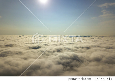 Aerial view over white clouds and clear blue sky. Aerial view over white clouds and clear blue sky. 131582315