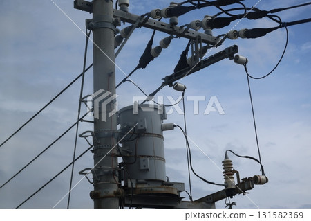 A close-up view of clouds, blue sky, transformers, power lines and utility poles A close-up view of clouds, blue sky, transformers, power lines and utility poles 131582369
