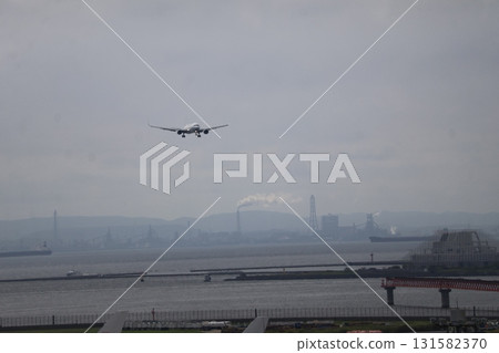A view of the hazy sky, mountains, industrial areas, and an airport with an airplane taking off A view of the hazy sky, mountains, industrial areas, and an airport with an airplane taking off 131582370