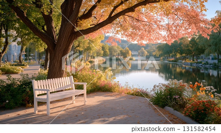 A white bench by a quiet pond surrounded by nature during the autumn foliage season 131582454