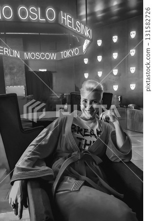 Smiling Woman in Robe Under Neon City Names Smiling Woman in Robe Under Neon City Names 131582726