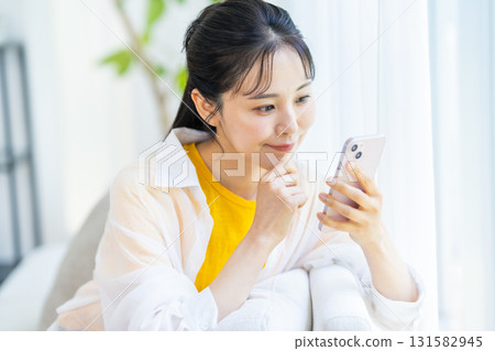 A woman who operates a smartphone in the room A woman who operates a smartphone in the room 131582945