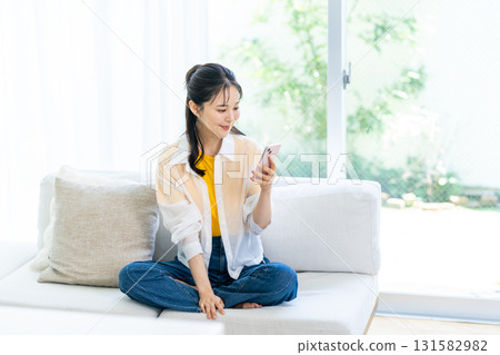 在房間裡操作智能手機的女人 在房間裡操作智能手機的女人 131582982