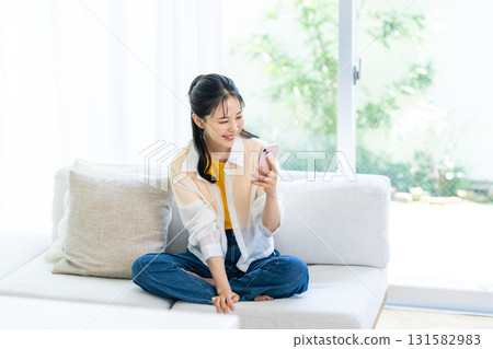 在房間裡操作智能手機的女人 在房間裡操作智能手機的女人 131582983